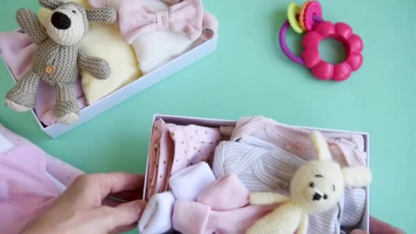 Женские Руки Собирают Детскую Одежду Коробки Концепция Подготовки Рождению Ребенка — стоковое видео