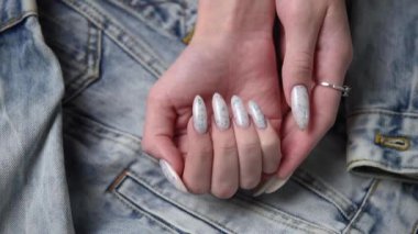 Kotun arka planında mavi tırnak desenli bir kadın eli. Mavi oje manikür.. 