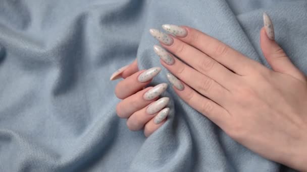 蓝宝石背景上有蓝色指甲图案的女性手 蓝色指甲油修指甲 — 图库视频影像