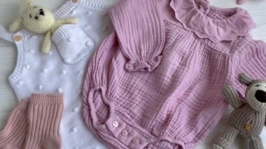 Oyuncak örgü oyuncaklar, çoraplar ve saç bandıyla pembe bir beden. Yazın bebek kıyafetleri ve aksesuarlar. Yeni doğan moda. Düz yatış, üst görünüm