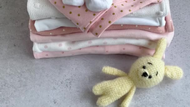 Stapelweise Babyanzüge Baby Strickspielzeug Aus Häschen Neben Einem Strampler Für — Stockvideo