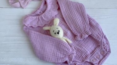 Oyuncak örgü oyuncaklar, çoraplar ve saç bandıyla pembe bir beden. Yazın bebek kıyafetleri ve aksesuarlar. Yeni doğan moda. Düz yatış, üst görünüm