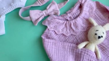 Oyuncak örgü oyuncaklar, çoraplar ve saç bandıyla pembe bir beden. Yazın bebek kıyafetleri ve aksesuarlar. Yeni doğan moda. Düz yatış, üst görünüm