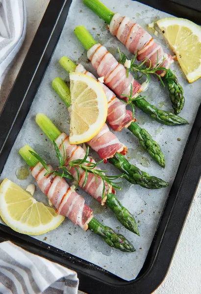 Asparagus with ham before baking in frying pan