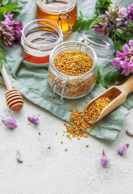 Çiğ organik arı poleni ve kavanozlarda bal ve akasya çiçekleri. 