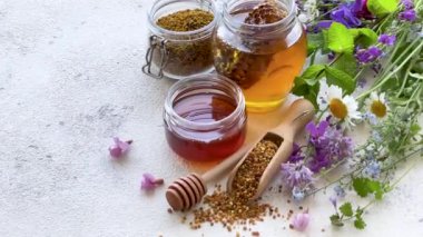 Çiğ organik arı poleni, kavanozlarda bal ve yabani çiçekler..