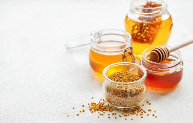 Çiğ organik arı poleni ve kavanozlarda bal.   