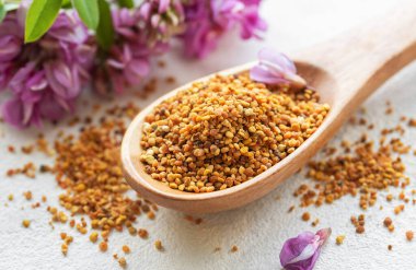 Sağlıklı arı poleni taneleri. Tahta kaşıkta arı poleni