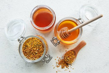 Çiğ organik arı poleni ve kavanozlarda bal.   