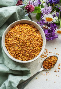 Sağlıklı arı poleni taneleri. Kasede arı poleni ve yabani çiçekler.