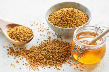 Çiğ organik arı poleni ve kavanozlarda bal.