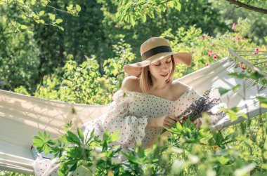 Arka bahçedeki hamakta dinlenen genç bir kadın.