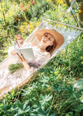 Arka bahçedeki hamakta dinlenen genç bir kadın.