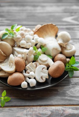 Ahşap arka planda çeşitli mantarlar var.