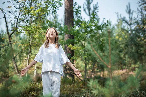 stock image A teenage girl who breathes fresh air and relieves stress in the forest. Dreamy peaceful relaxed girl breathing the fresh air of nature.