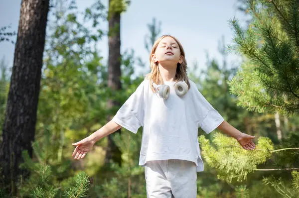 Stock image A teenage girl who breathes fresh air and relieves stress in the forest. Dreamy peaceful relaxed girl breathing the fresh air of nature.