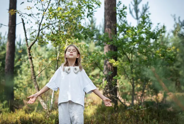 stock image A teenage girl who breathes fresh air and relieves stress in the forest. Dreamy peaceful relaxed girl breathing the fresh air of nature.