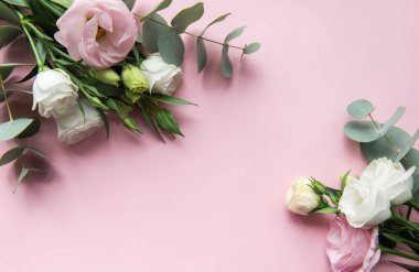 Hassas pastel çiçekler, yumuşak pembe bir zemine karşı gür okaliptüs yapraklarıyla zarif bir şekilde düzenlenir. Olaylar için ideal taze ve davetkar bir atmosfer yaratır..