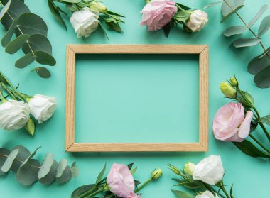 Merkeze, yeşil arkaplanda okaliptüs yaprakları bulunan beyaz ve pembe güllerle çevrili ahşap bir çerçeve yerleştirilerek taze ve canlı bir estetik oluşturulur..