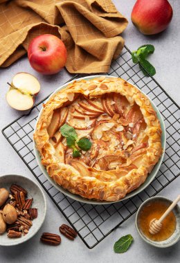 Taze pişmiş elma galetesi serinletici rafta dinleniyor. Yanında bal, ceviz ve taze nane var.