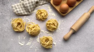 Şef, taze fettucine makarna yuvaları, yumurtalar ve merdane iğnesinden oluşan tezgahın son rötuşlarını yapar.