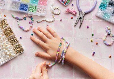Çocuk el yapımı mücevherler yapıyor, rahatlatıcı bir hobisi var.