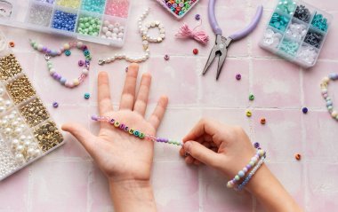 Çocuk el yapımı mücevherler yapıyor, rahatlatıcı bir hobisi var.