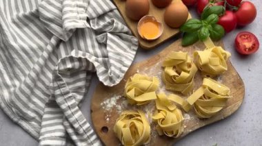 Şef makarna, domates, sarımsak ve fesleğen hazırlıyor.