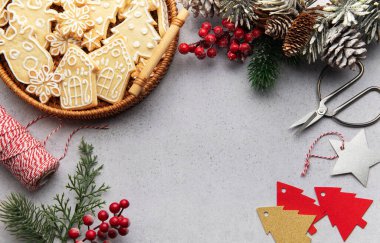 Christmas composition with gingerbread cookies, pine cones, ornaments, and crafting supplies on a gray background, evoking a warm and festive holiday spirit clipart