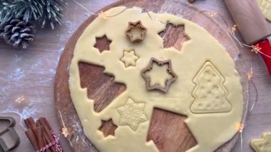 Baker hamurdan noel kurabiyesi kesicileri çıkarıyor