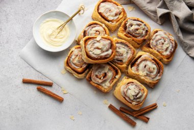 Lezzetli tarçınlı börekler, krem peynirli şekerlemeler ve badem dilimleri serpiştirilmiş tatlı ve cezbedici bir ikram sunar.