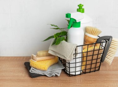 İçinde deterjanlar, fırçalar, süngerler ve bezler de dahil olmak üzere çevre dostu temizlik malzemelerinin bulunduğu sepet, sürdürülebilir temizlik uygulamaları sergileniyor.