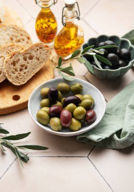 Yeşil ve siyah zeytinler sağlıklı bir Akdeniz diyetinin parçası olarak zeytin yağı ve ekmekle servis edilir.