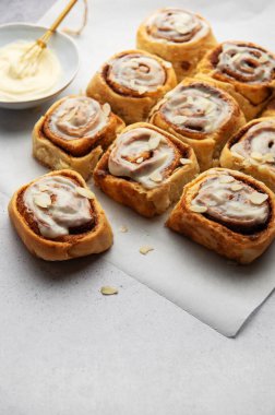 Lezzetli tarçınlı börekler, krem peynirli şekerlemeler ve badem dilimleri serpiştirilmiş tatlı ve cezbedici bir ikram sunar.