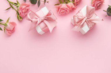 Pembe güller ve pembe arka planda hediye kutularıyla Sevgililer Günü yaratıcı planı