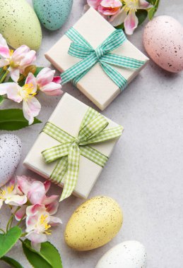 Pastel yumurta ve çiçekli hediye kutuları.