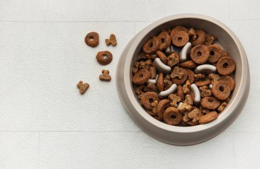 Hafif bir yüzeyde yavaş beslenen bir kasede köpek maması.