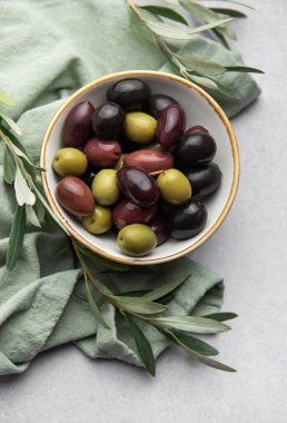 Zeytin dallarıyla dolu bir kasede renkli zeytinler servis edilir. Akdeniz aperatifi oluşturur.