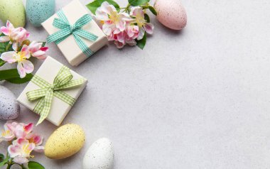 Pastel yumurta ve çiçekli hediye kutuları.