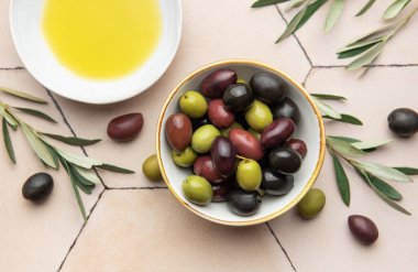 Renkli zeytinler, zeytinyağı ve zeytin dalları Akdeniz mutfağı sahnesi oluşturur