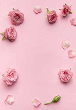 Pembe güller ve taç yaprakları pembe arka planda bir çerçeve oluşturuyor. Romantik ya da kadınsı temalar için ideal.