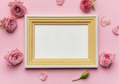 Pembe güller ve taç yapraklarıyla süslenmiş ahşap çerçeve romantik bir ortam yaratır. Sevilen anıları veya sanat eserlerini sergilemek için idealdir.