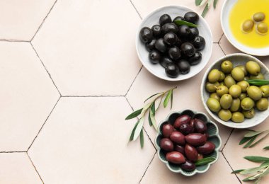 Zeytinyağı ve kiremit kaplı bir yüzeyde dallarla çeşitli zeytinler.