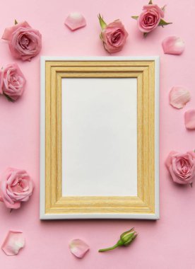 Pembe güller ve taç yapraklarıyla süslenmiş ahşap çerçeve romantik bir ortam yaratır. Sevilen anıları veya sanat eserlerini sergilemek için idealdir.