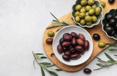 Tahtaya dizilmiş çeşitli zeytinler canlı ve iştah açıcı bir görüntü oluşturuyor.