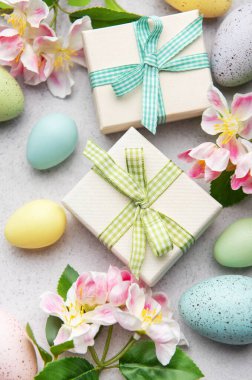 Paskalya yumurtaları ve bahar çiçekli hediye kutuları Paskalya kutlaması için güzel bir süs oluşturuyor.