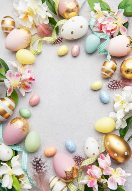 Paskalya yumurtaları, çiçekler ve tüylerle gri bir zemin oluşturarak merkezde bir kopya alanı oluşturur.