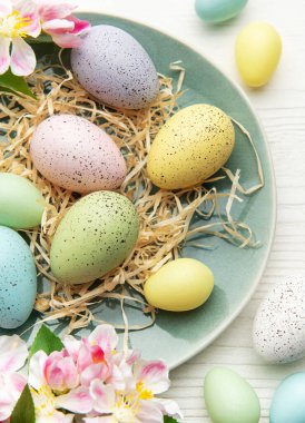 Ahşap bir yüzeyde çiçekli renkli paskalya yumurtaları