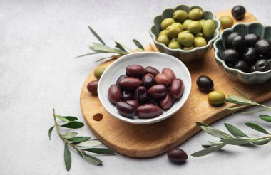 Tahtaya dizilmiş çeşitli zeytinler canlı ve iştah açıcı bir görüntü oluşturuyor.