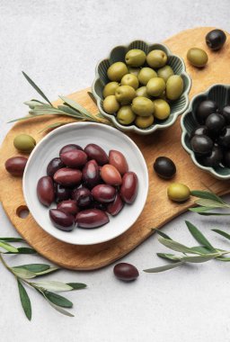 Tahtaya dizilmiş çeşitli zeytinler canlı ve iştah açıcı bir görüntü oluşturuyor.